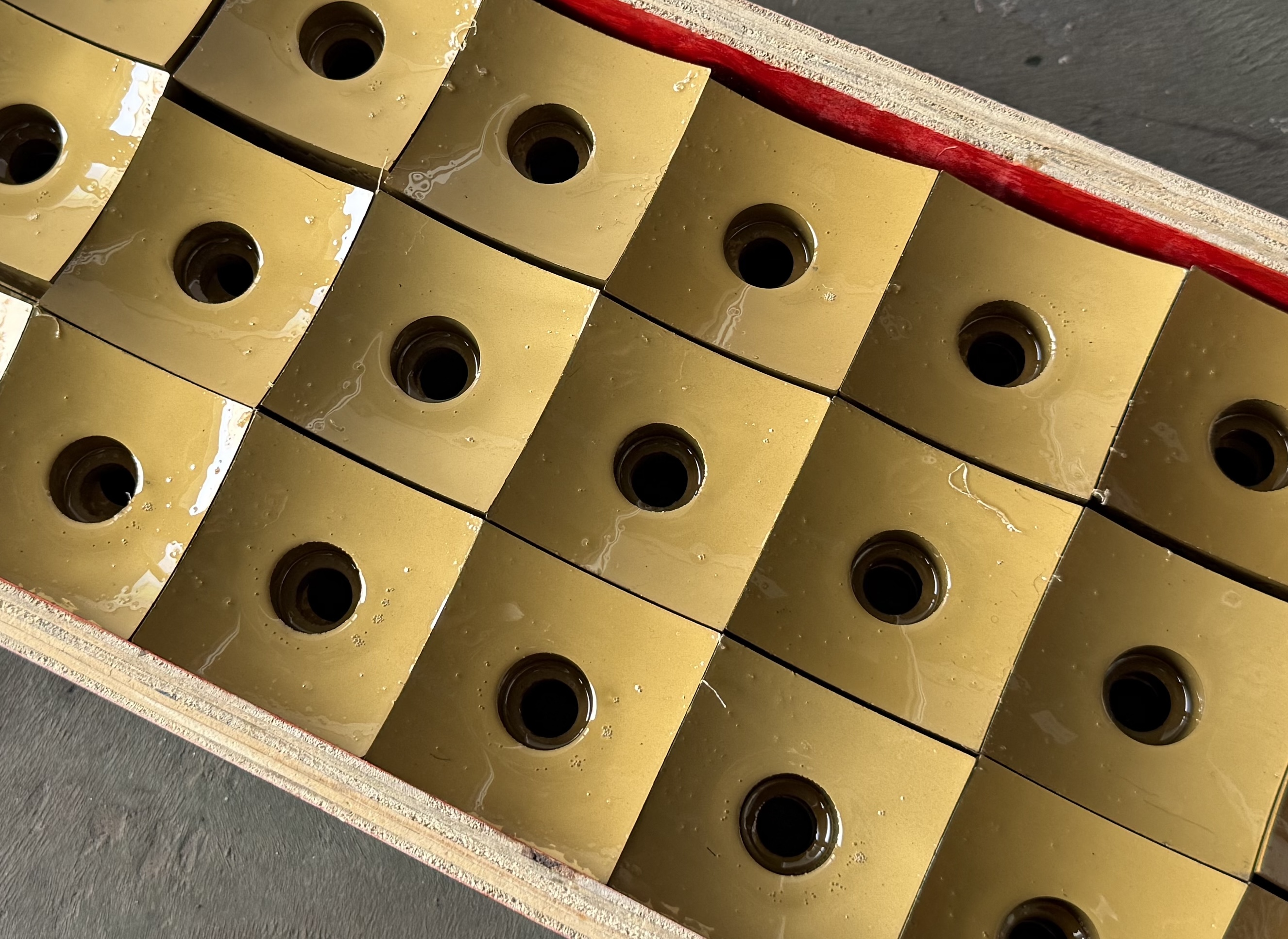 Angled close-up of finished TiN-coated cutter inserts with central mounting holes
